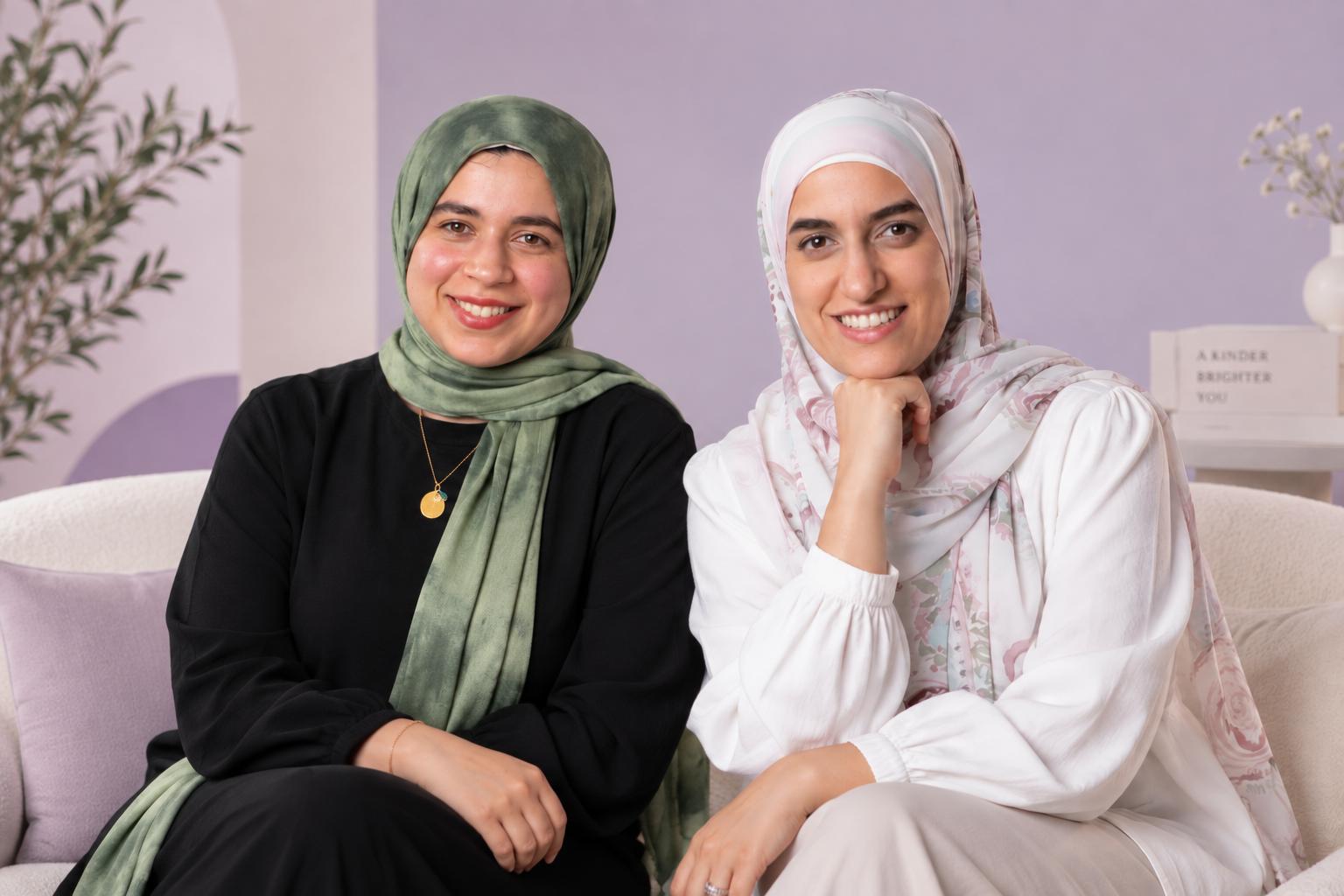 Safe Space's two founders sitting together on a sofa, smiling.